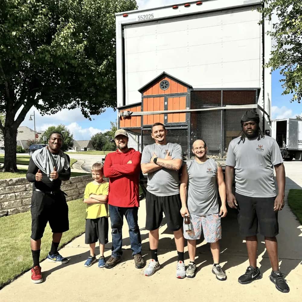 Muscleman Moving team posing with happy customer and moving boxes