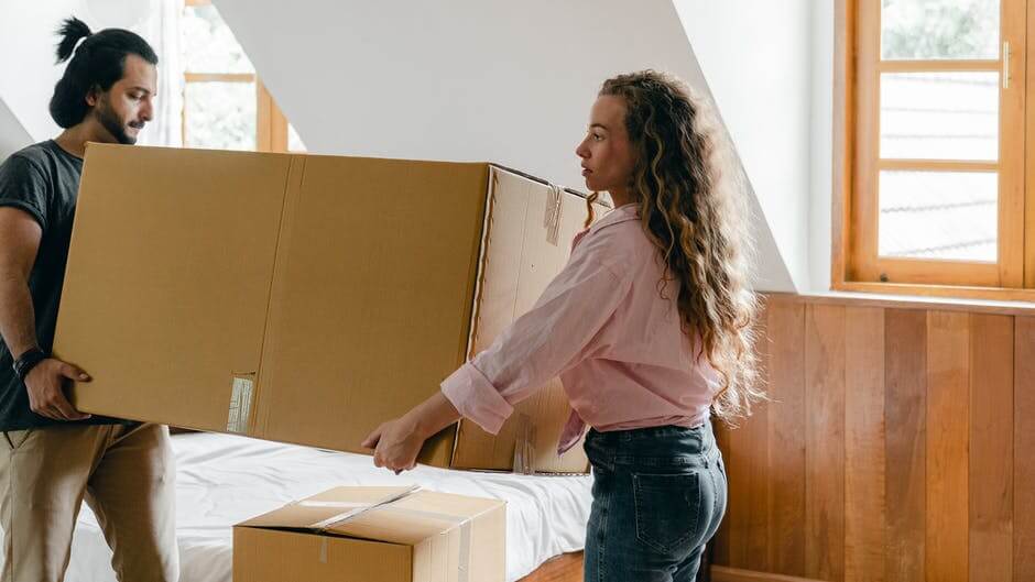 Couple holding moving boxes
