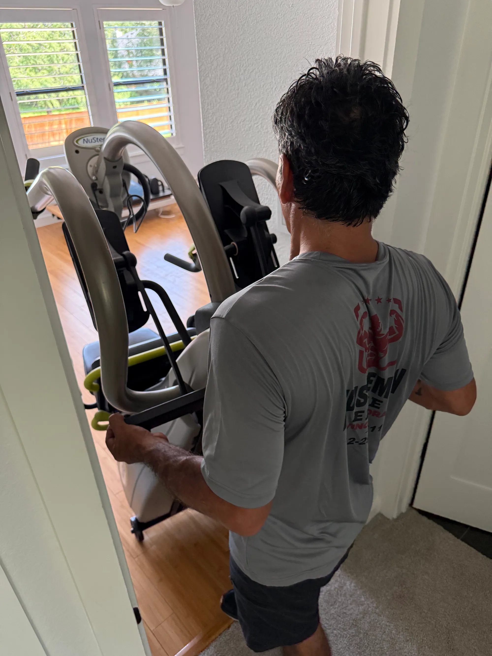 Muscleman Elite mover carrying heavy gym equipment through a doorway