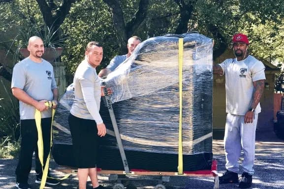Muscleman Elite movers carefully relocating a grand piano