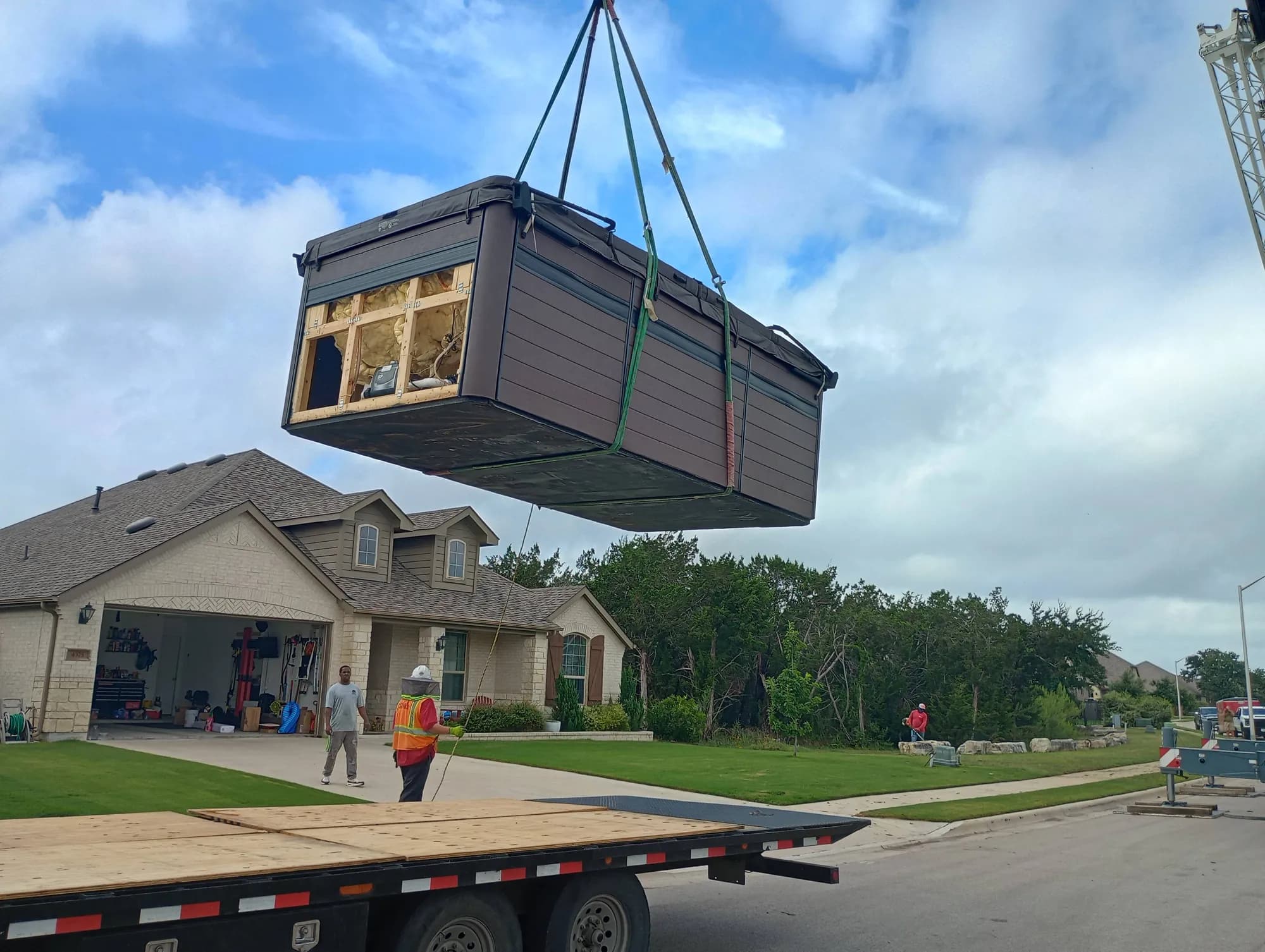 Muscleman Elite craning a hot tub over a house onto a flatbed during a spa move