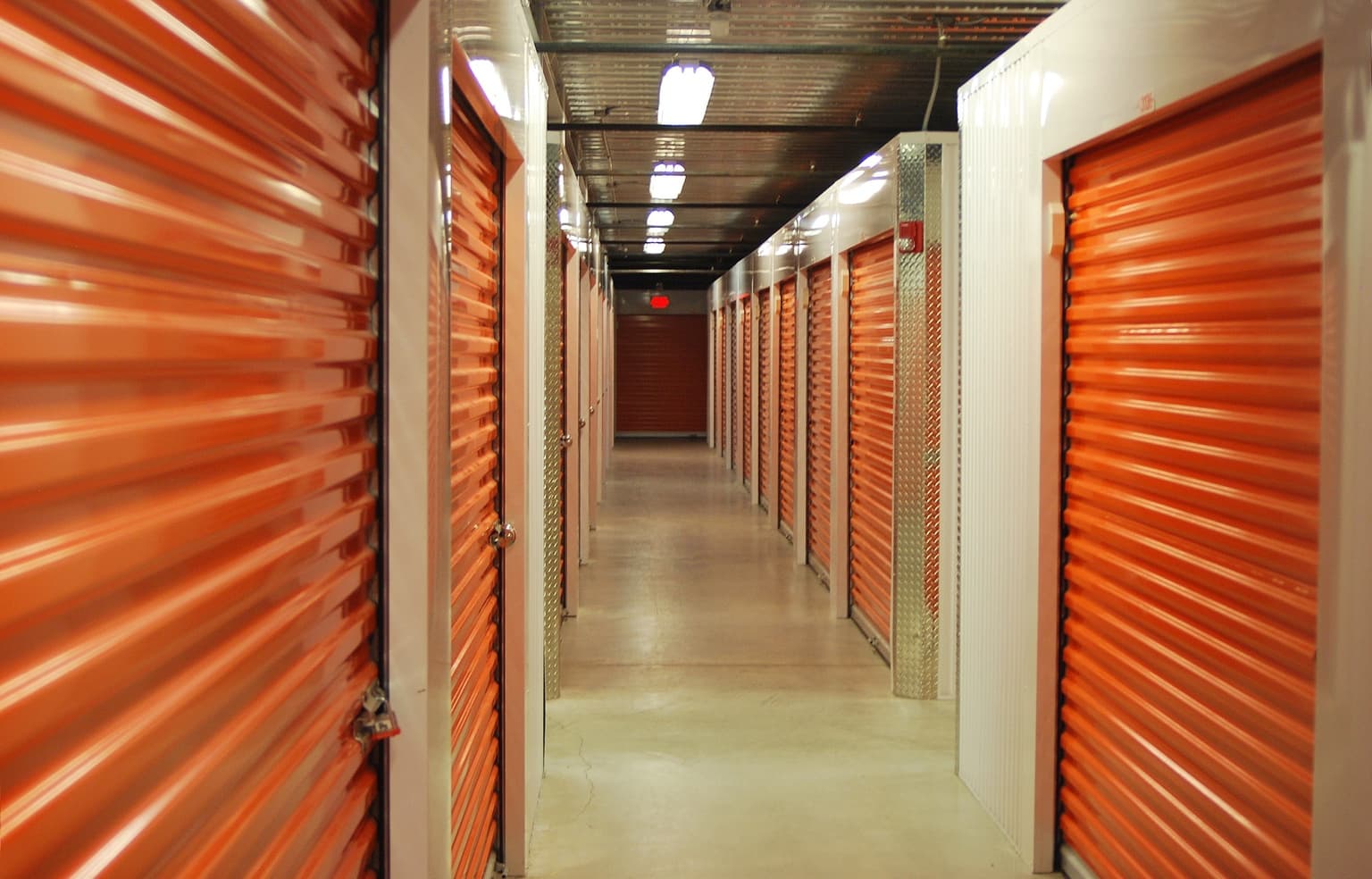 Clean and secure self-storage facility hallway with orange doors