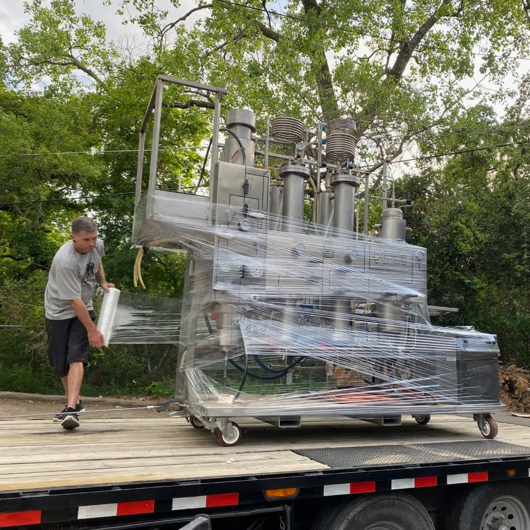 Heavy commercial machinery being moved by specialty crew