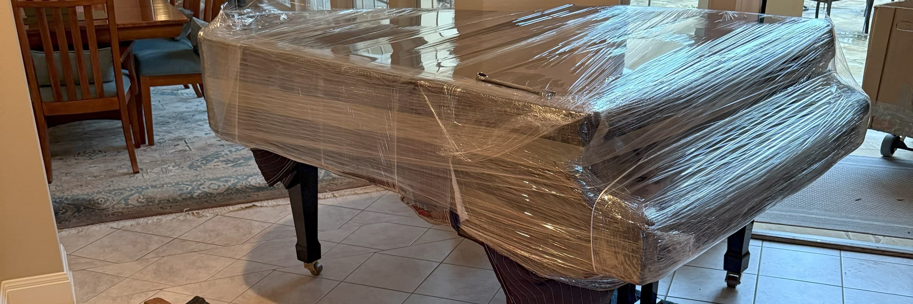 MuscleMan Elite crew moving a grand piano down a staircase