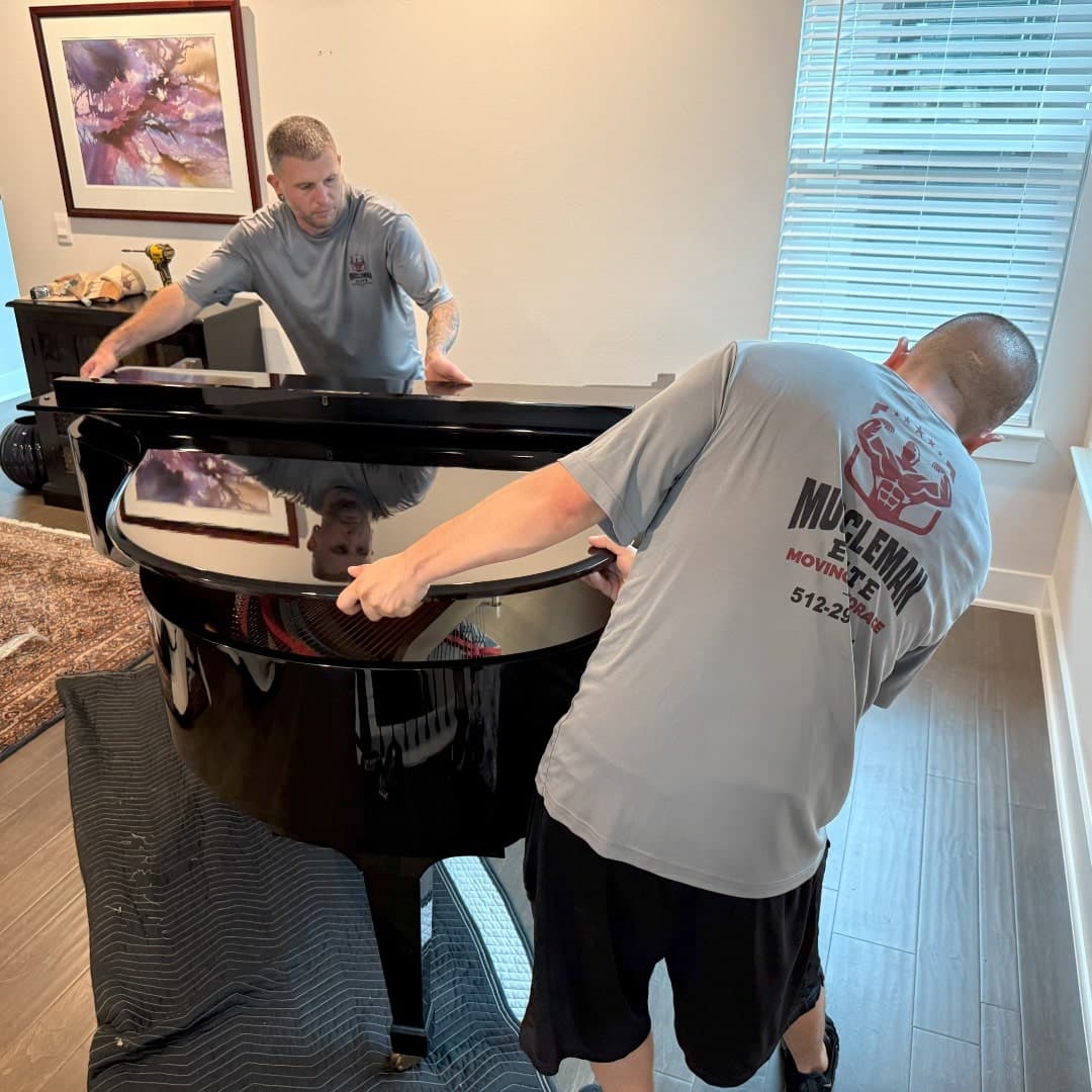 Crew carefully lifting a grand piano onto a dolly