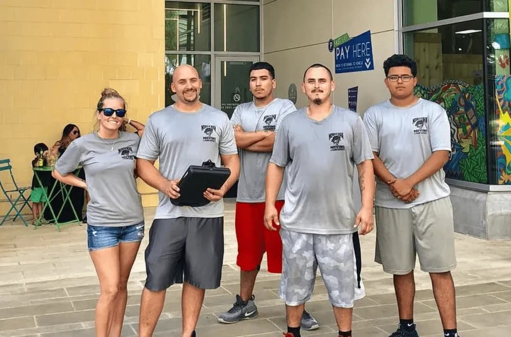 Muscleman Moving crew wrapping and protecting furniture for transport