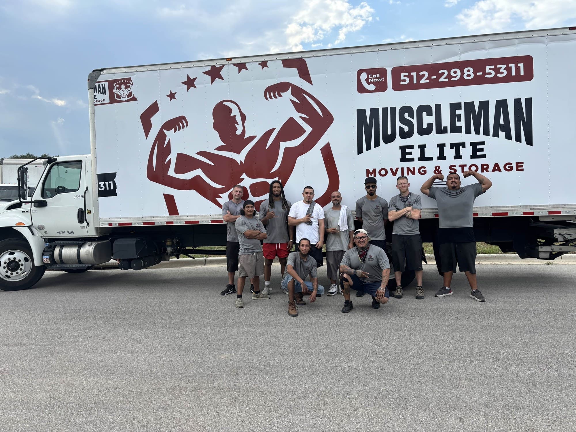 Muscleman Elite moving crew standing in front of a branded box truck in the Austin area