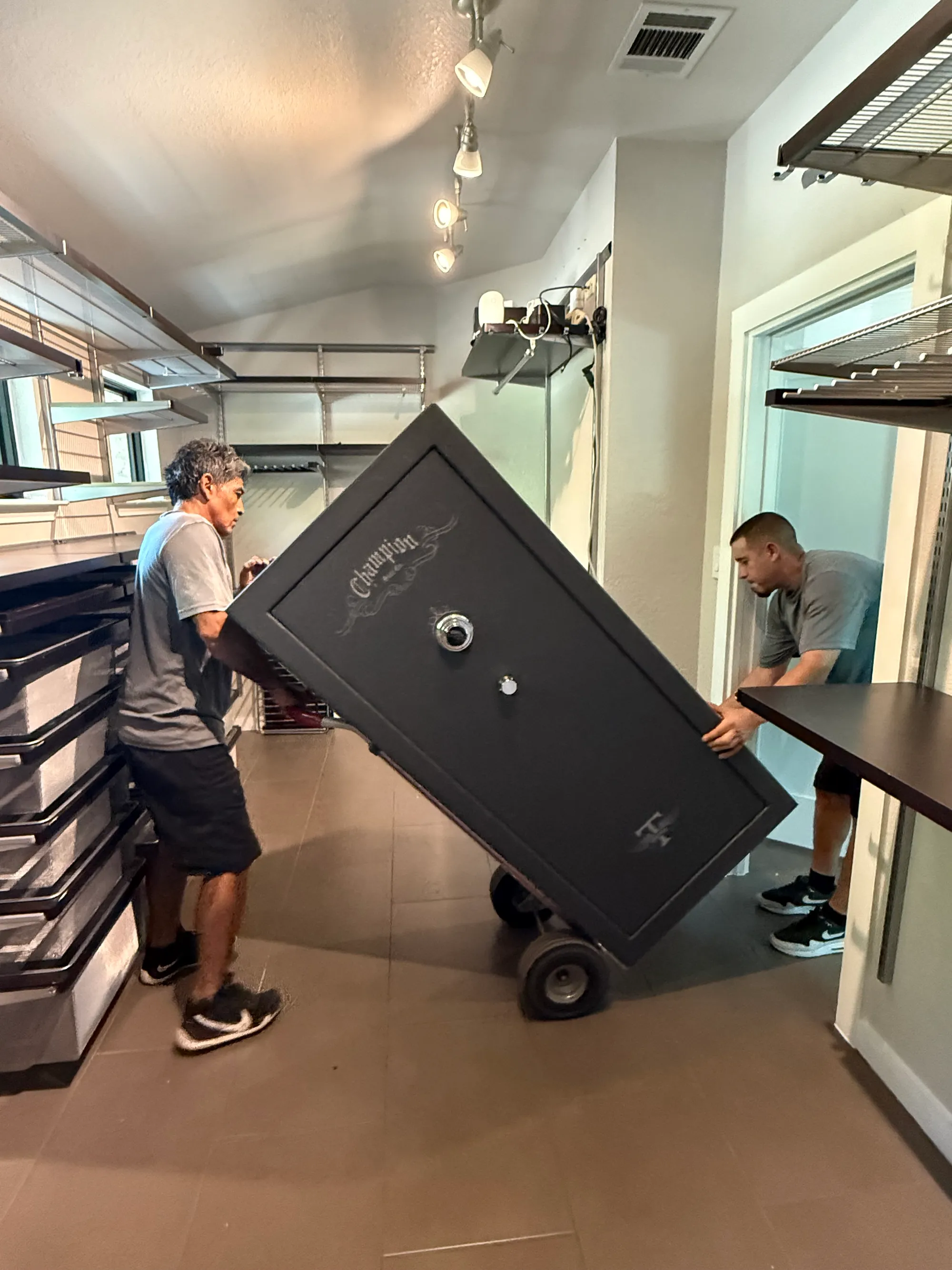 Muscleman Elite crew maneuvering a gun safe on a heavy-duty dolly