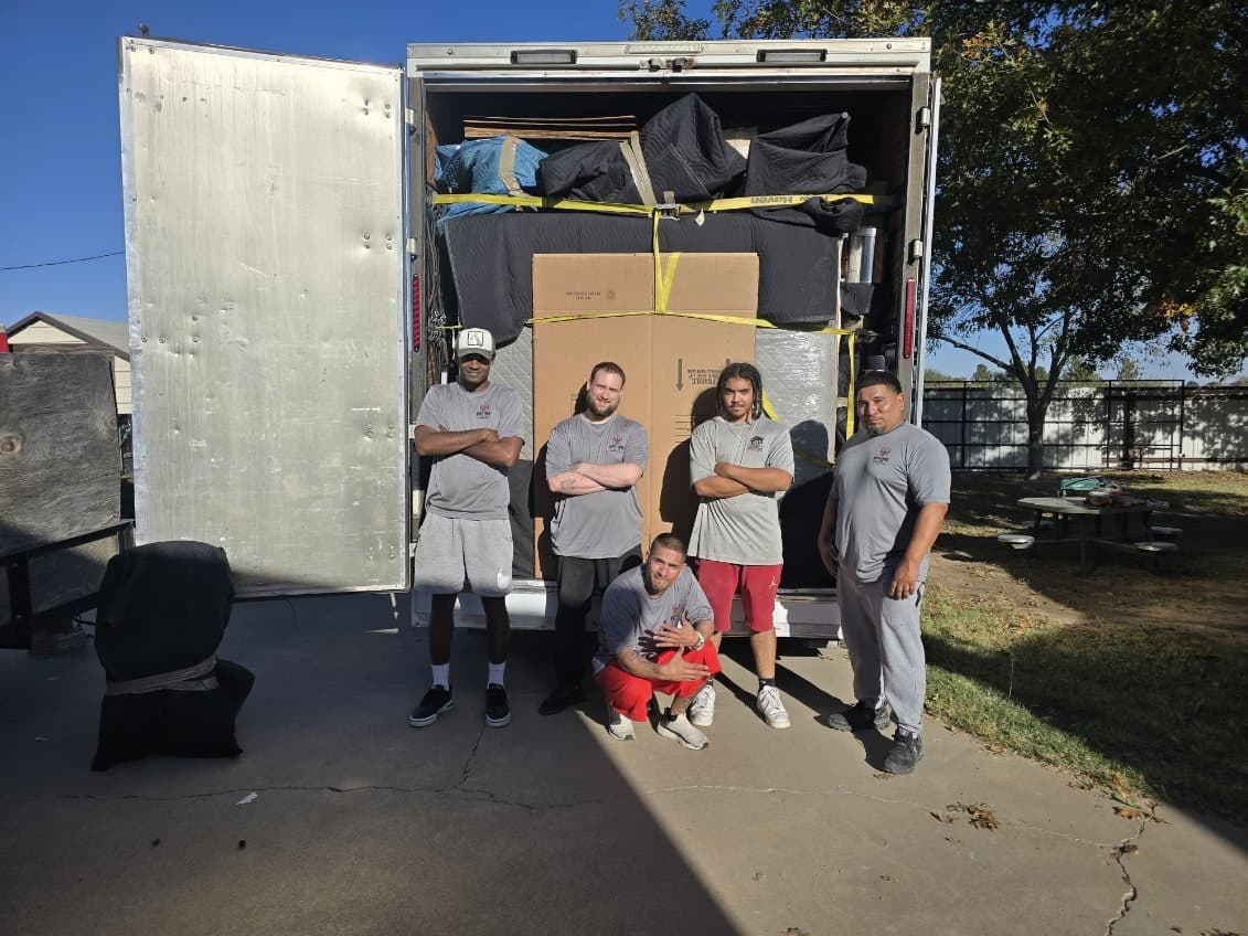 Muscleman Elite crew at the back of a branded truck on a Midland job