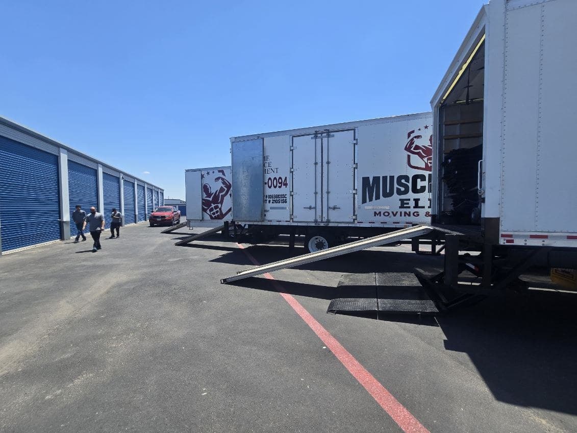 Muscleman Elite crew loading a wrapped item up the truck ramp