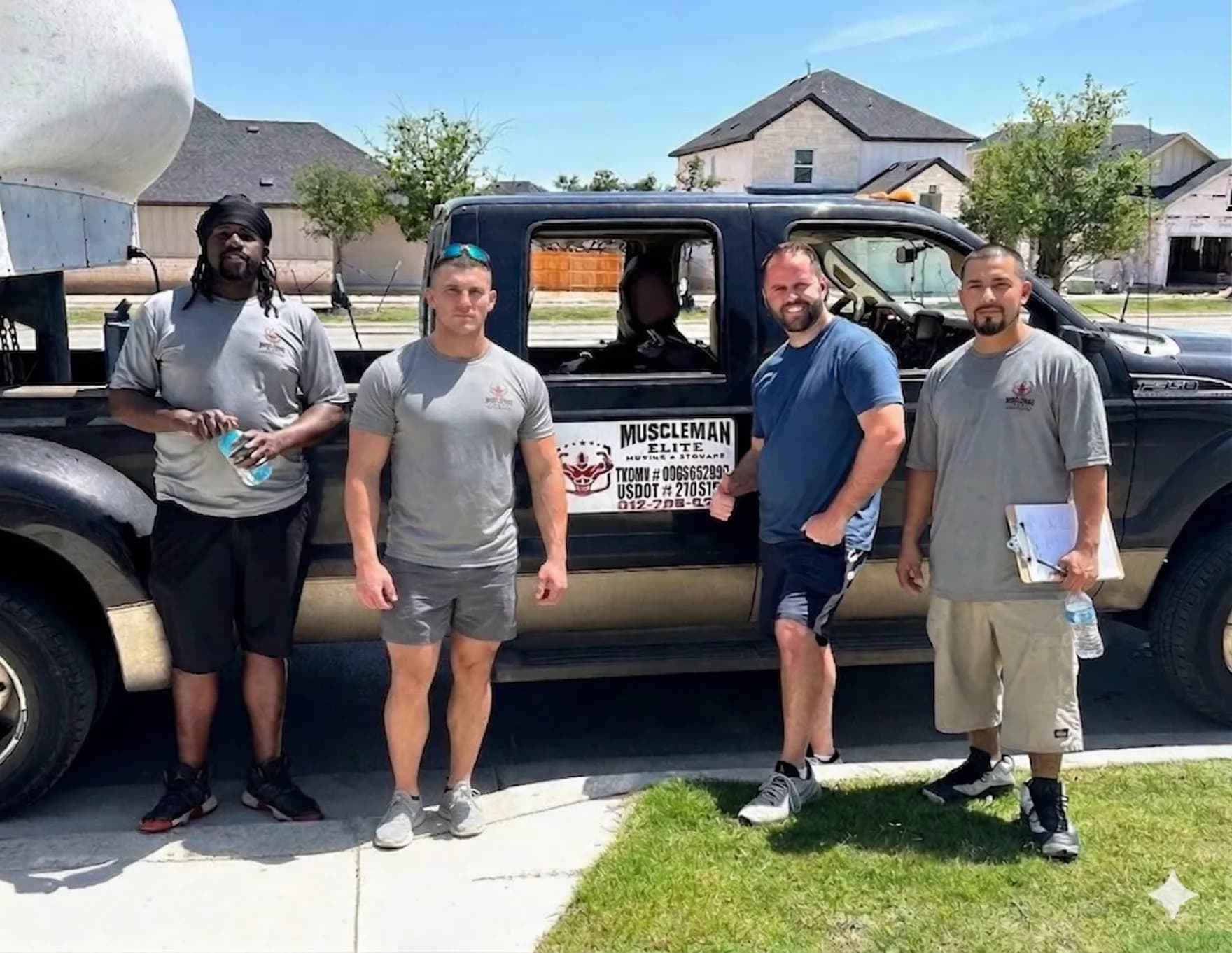 Muscleman Elite Moving crew with happy customer after completing an Austin home move